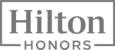 The image shows the logo for Hilton Honors, with "Hilton" in large text and "HONORS" below it in smaller, capitalized text.